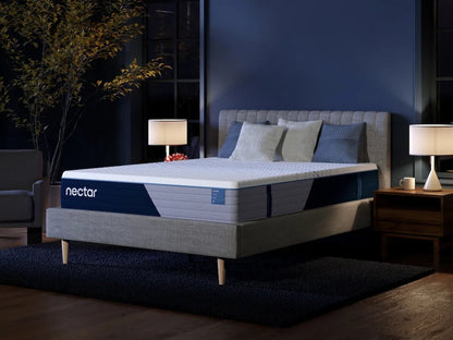 Nectar Classic mattress on a gray upholstered bed in a navy bedroom, with a white quilted top and navy-and-gray side panels.